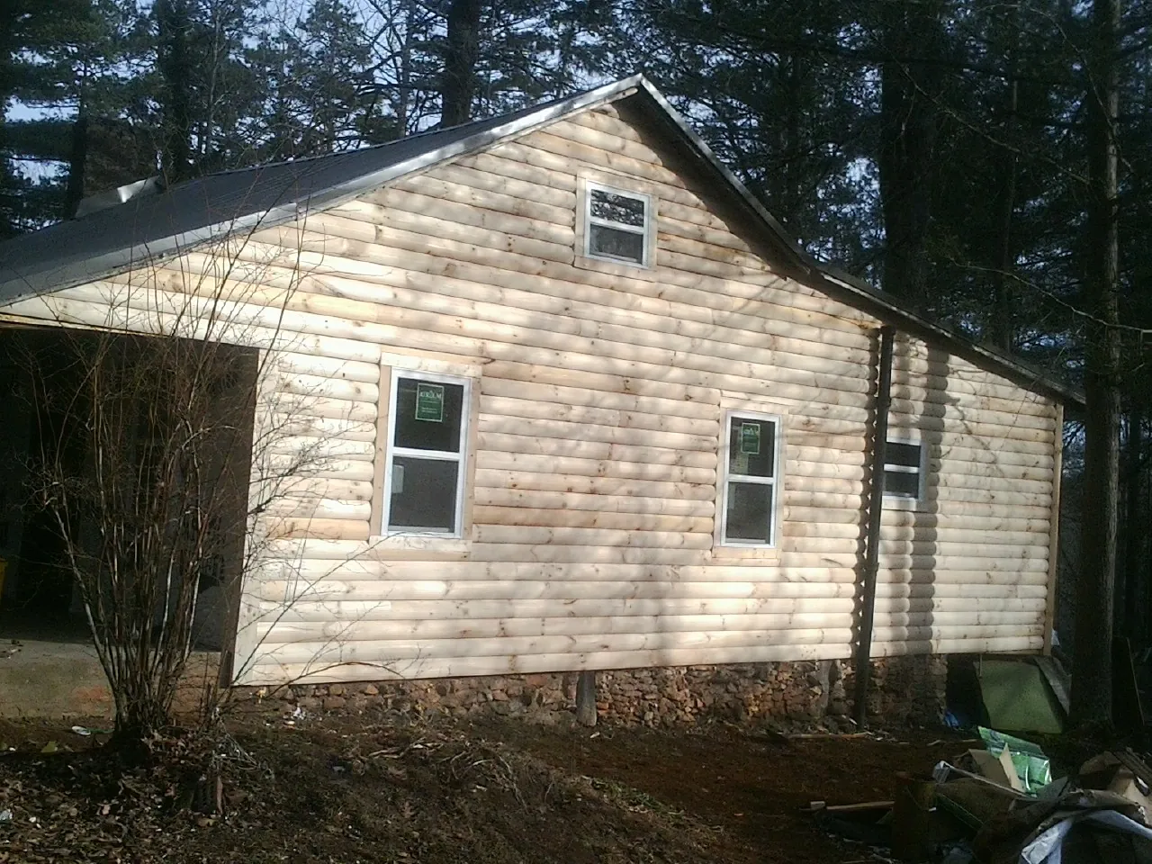 New log siding and dark metal roofing on a gable end in Green Bay