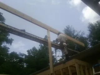 Carpenter setting a ridge beam over a new addition frame — Ice Dam Removal by Roofing Brothers in Green Bay