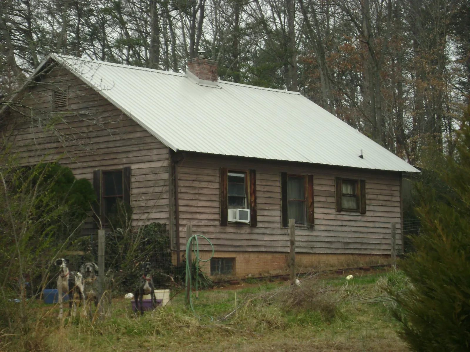 White metal roof on an old wood sided farmhouse, from a Metal Roof Installation job in Green Bay